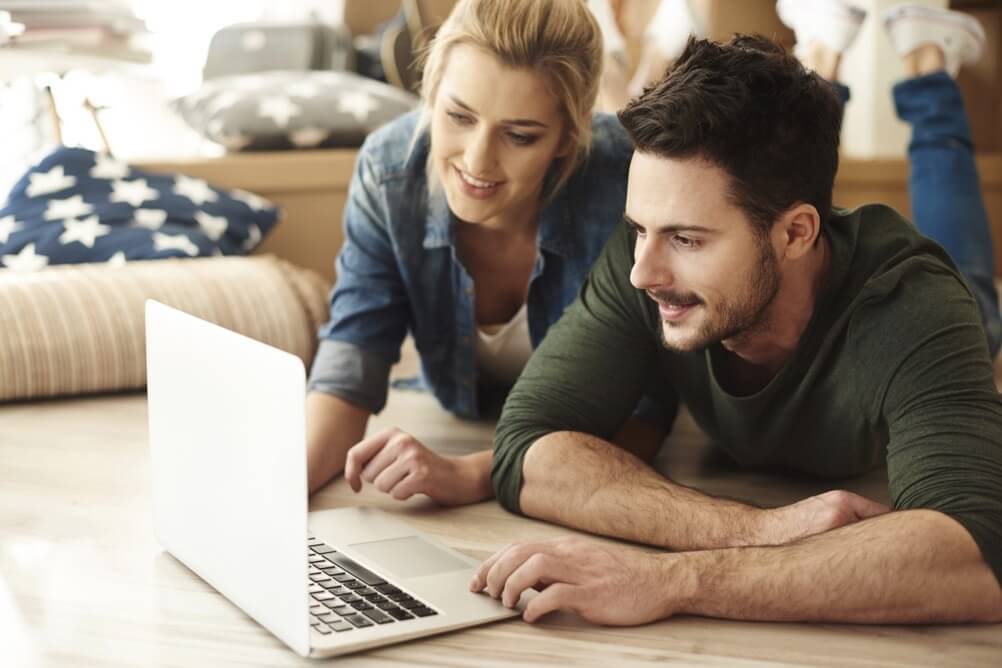 Ein Mann und eine Frau benutzen einen Laptop, um ihre Tippscheine online abzugeben