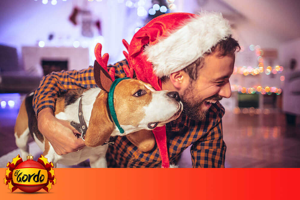 Ein Mann mit einem Hund freut sich über ein Weihnachtslos.