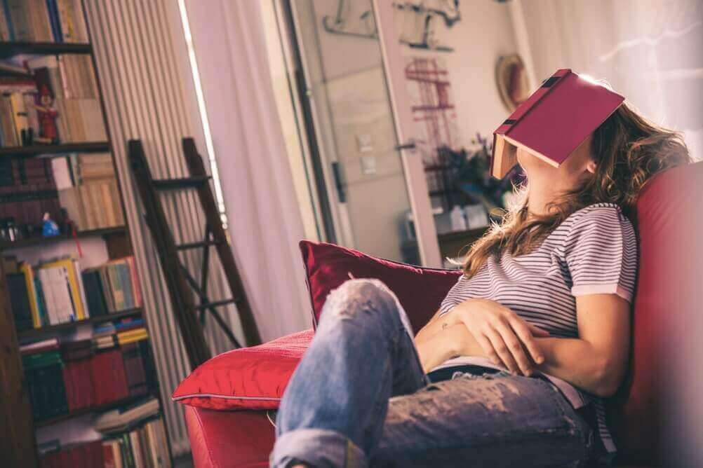 Tédio em casa - uma mulher entediada dormindo debaixo de um livro 