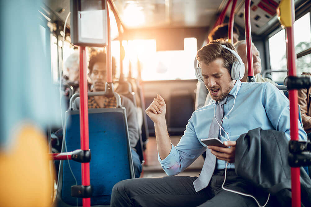 Homem feliz ouvindo música rock no ônibus