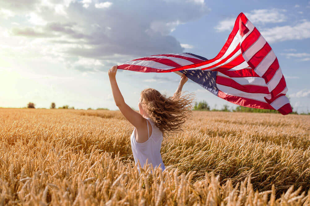 Uma garota carregando uma bandeira dos EUA no campo e celebrando maior prêmio de loteria do mundo 