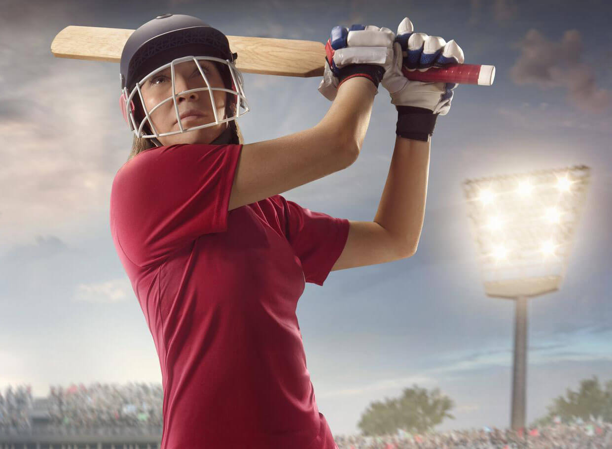 Cricket betting female cricket player batswoman swinging bat in packed stadium