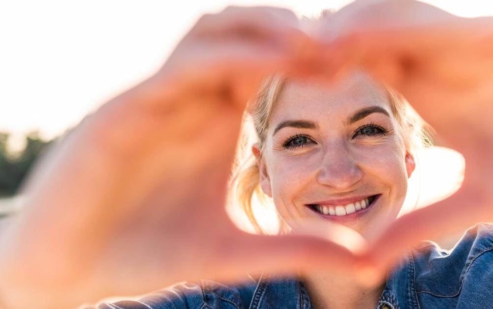 Menina faz coração com as mãos para celebrar os 20 milhões de clientes da Lottoland Loterias