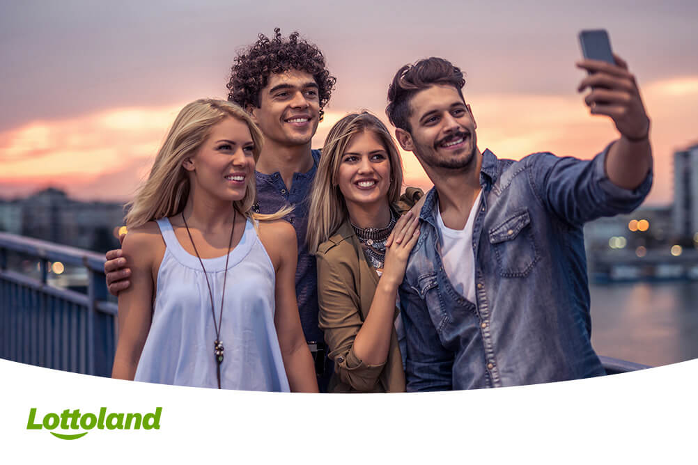 Lottogewinn abholen - so zahlt das Lottoland die Gewinne aus Vier Freunde machen ein Selfie nachdem sie ihren Lottogewinn abgeholt haben
