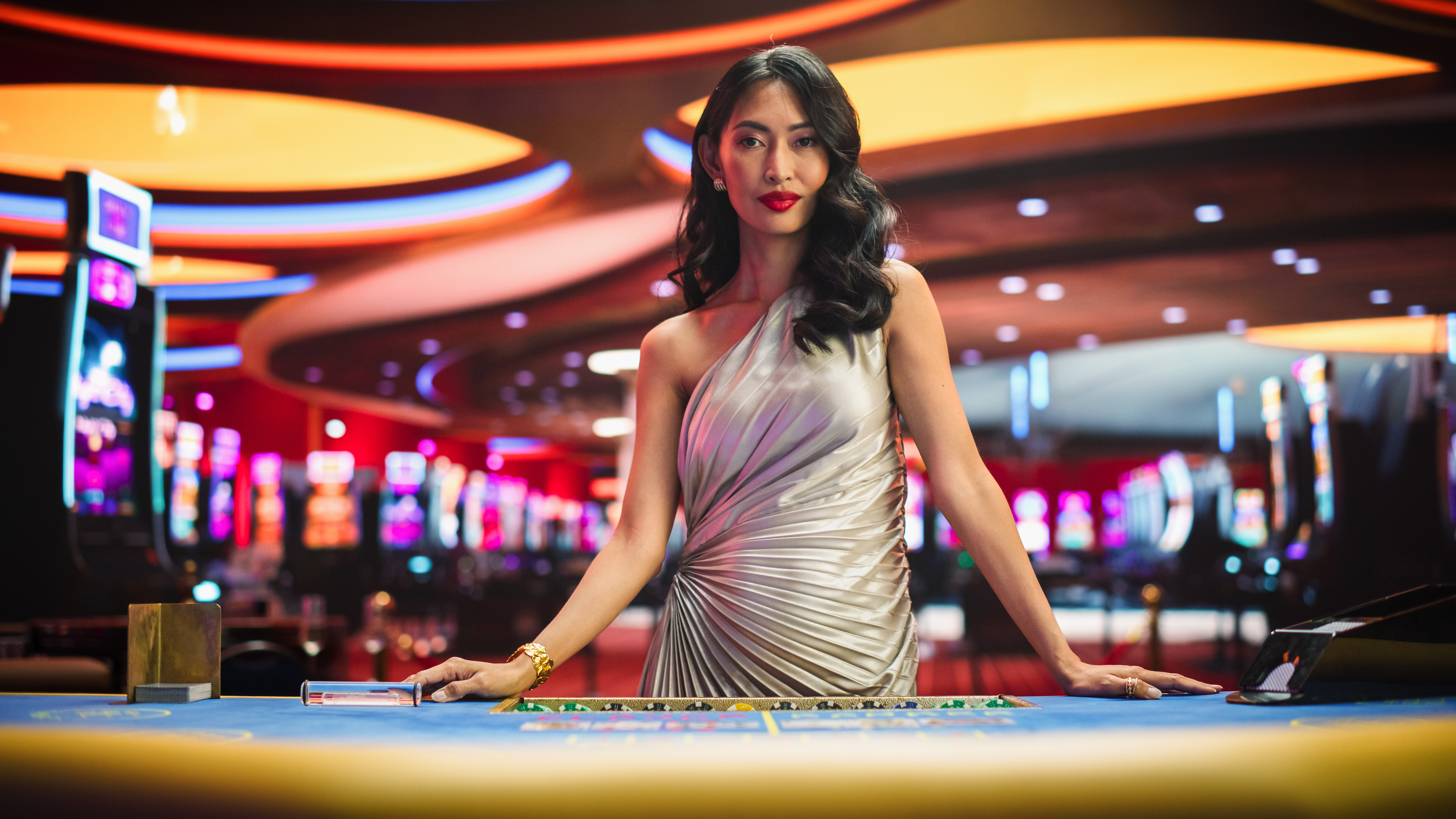 A female croupier getting ready top deal blackjack hands in a brightly lit casino