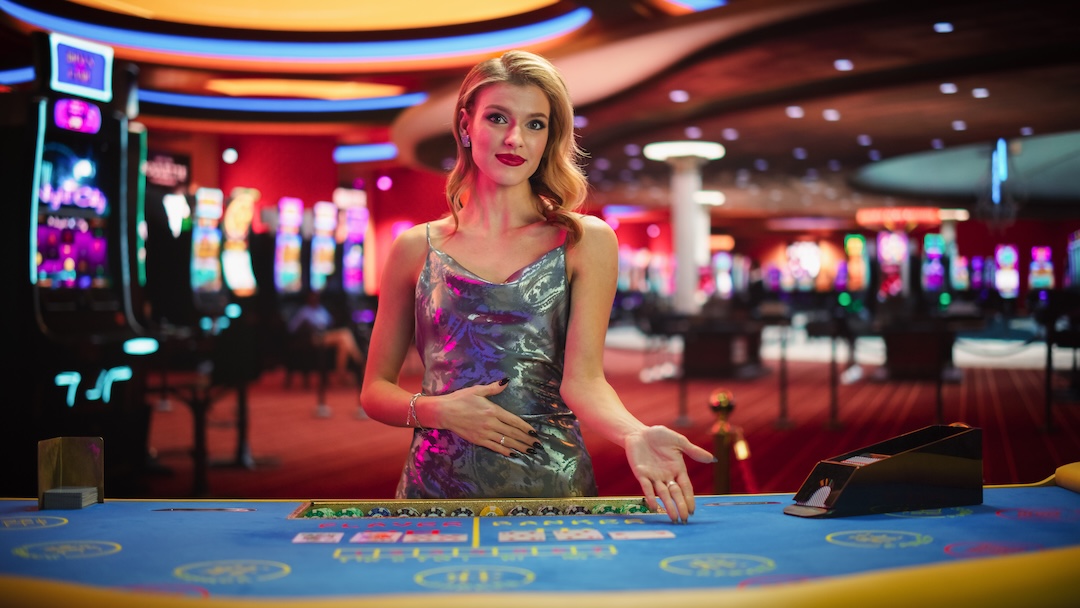 A female croupier standing over a poker table in a casino